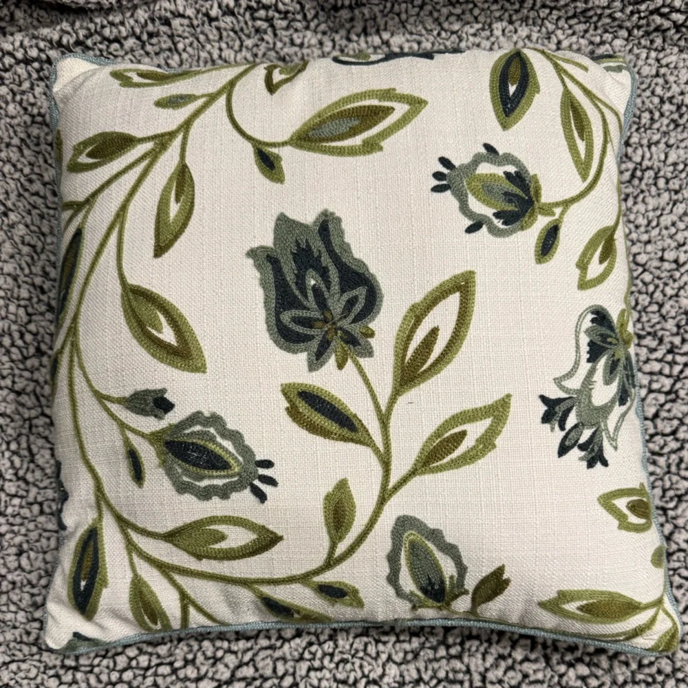 Two decorative pillows with green/blue tulip design.